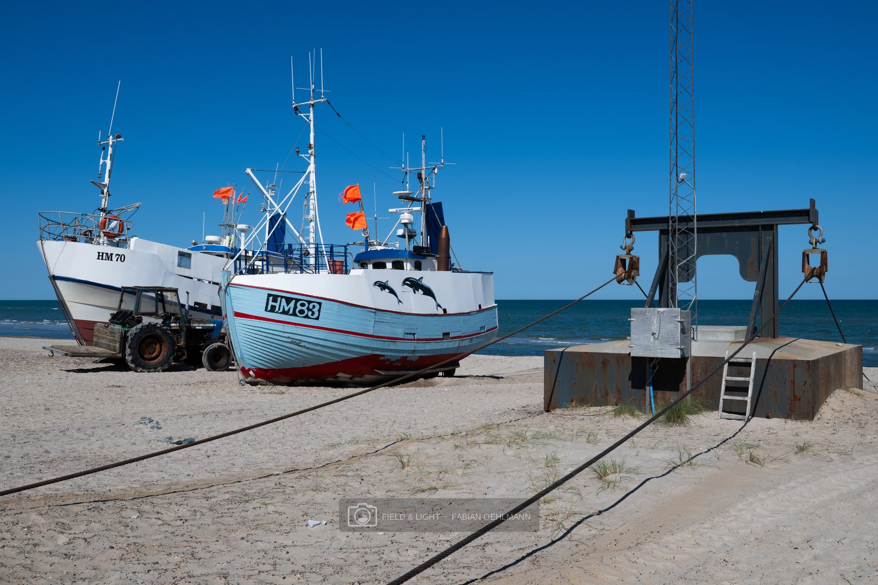 Fishing boats, tractor and hauling gear on the working beach at Thorup Strand